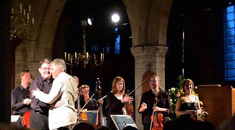 Composer David Matthews and Artistic Director George Vass, with members of the Festival Orchestra, celebrate at the 2004 Presteigne Festival of Music and the Arts. Photo © Keith Bramich